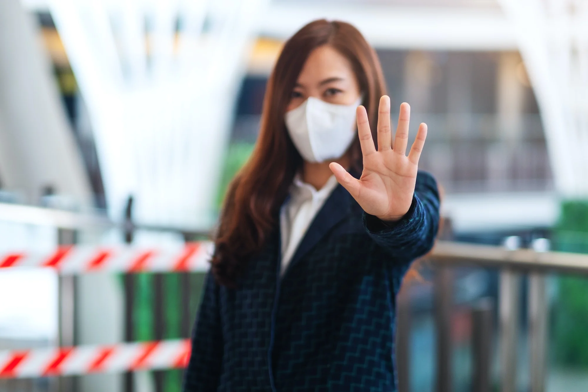 woman wearing protective face mask, making stop hand sign