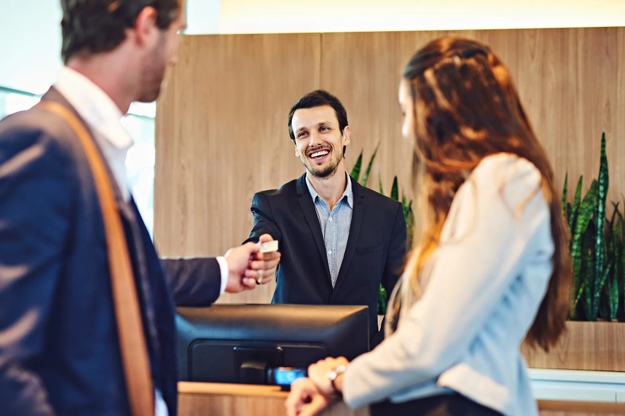 Time to pay for your stay. Cropped shot of a businessman and businesswoman checking into a hotel.