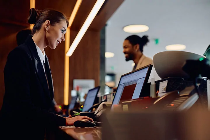 Hotel front desk agent assisting a guest during check in