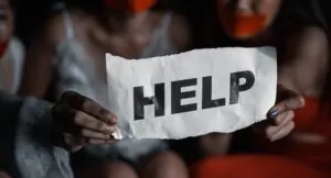 Asian woman victims holding paper with texts asking for help